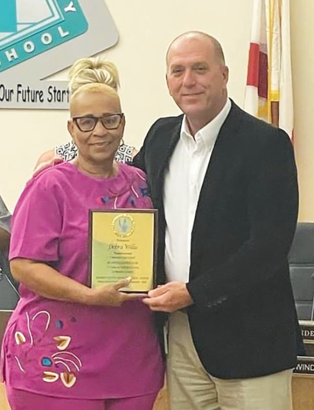 Debra Willis receives a plaque of recognition for her 32 years of service from Hendry County School District Superintendent Michael Swindle. Willis is retiring from her position as paraprofessional at Clewiston High School.